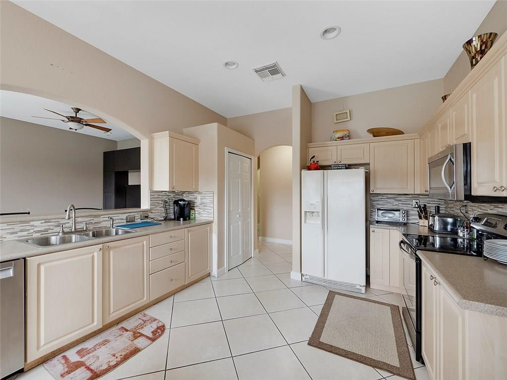12980 Southwest 52nd Street Miramar, FL 33027 - Photo 6 of 17 a large white kitchen with a sink and refrigerator