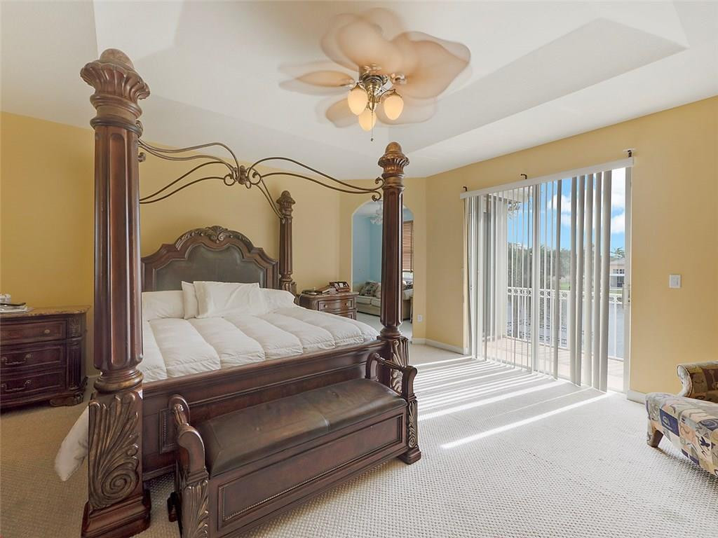 12980 Southwest 52nd Street Miramar, FL 33027 - Photo 8 of 17 a bedroom with a bed a chandelier and a dresser