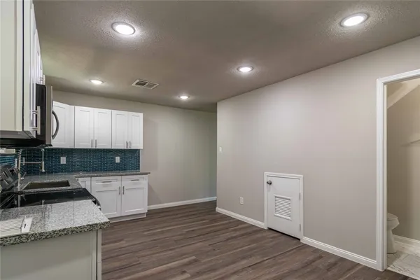 a kitchen with a sink and wooden floor