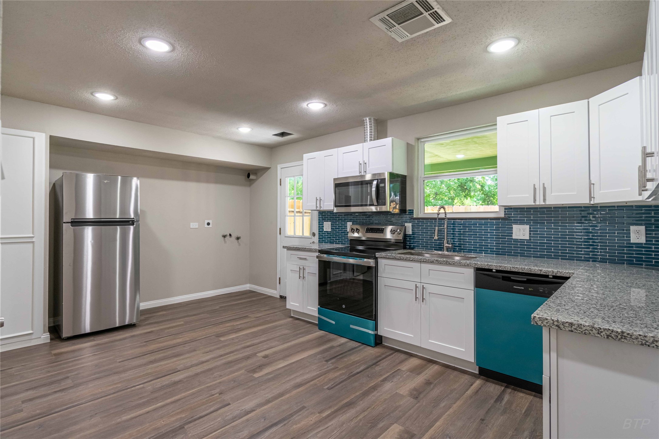 7921 Cook Road Houston, TX 77072 - Photo 5 of 19 a kitchen with stainless steel appliances granite countertop a refrigerator a sink dishwasher a stove and white cabinets with wooden floor