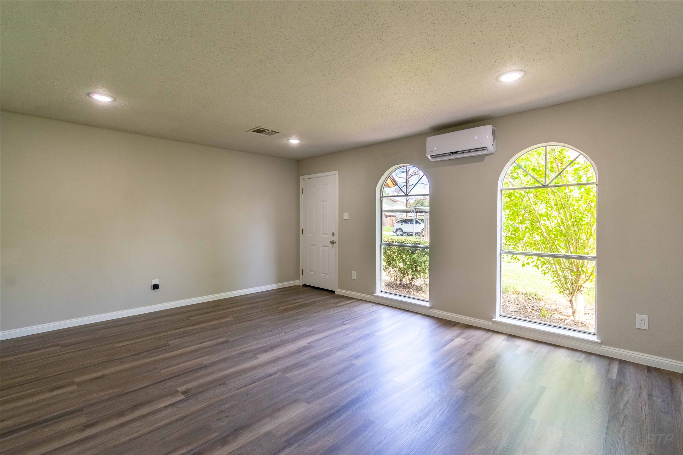 7921 Cook Road Houston, TX 77072 - Photo 7 of 19 an empty room with wooden floor and windows