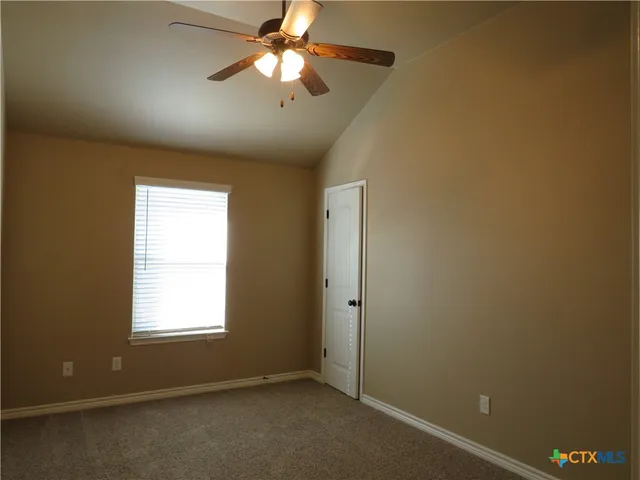an empty room with a chandelier fan and a chandelier fan