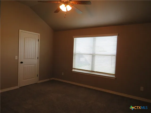 an empty room with closet and a chandelier fan
