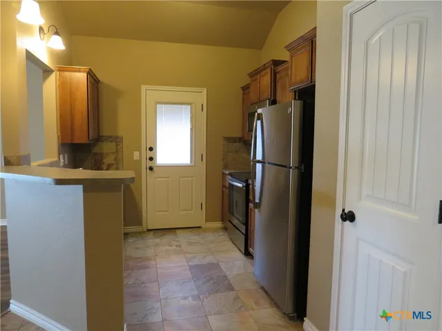 a kitchen with a refrigerator a stove top oven a sink and dishwasher