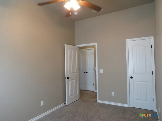 an empty room with a window and a fan