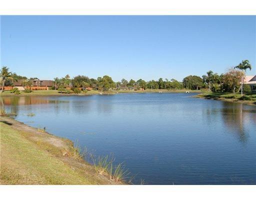 5768 Southeast Windsong Lane Stuart, FL 34997 - Photo 5 of 15 a view of a lake with houses in the back