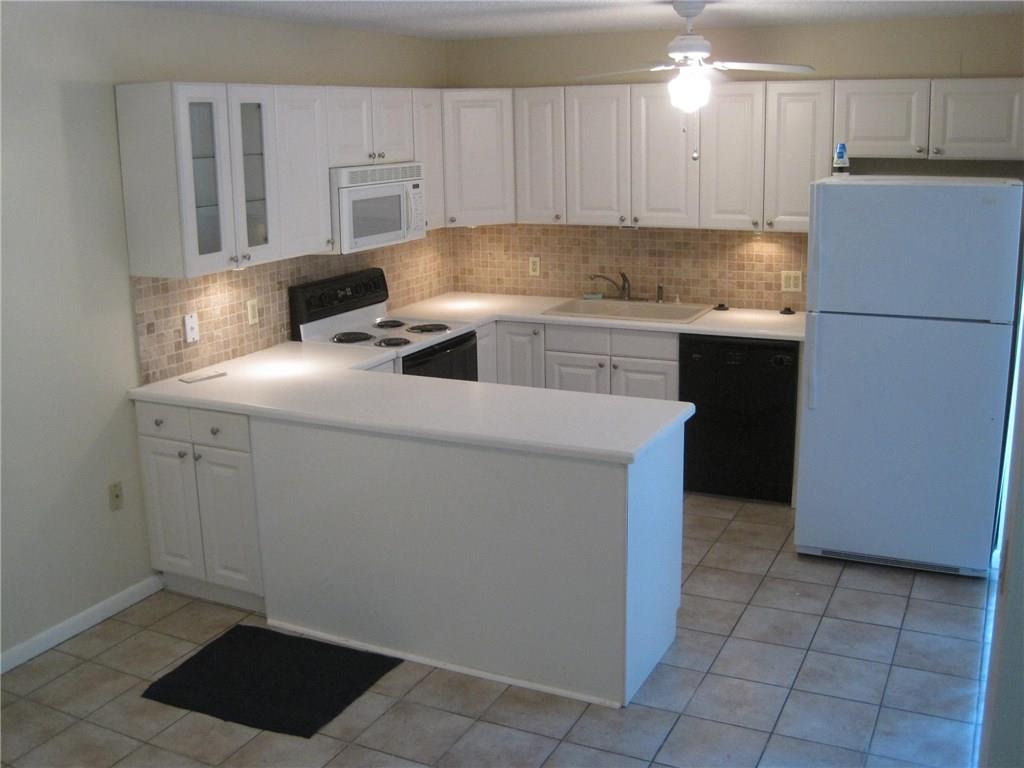 5768 Southeast Windsong Lane Stuart, FL 34997 - Photo 9 of 15 a kitchen with a sink cabinets and a refrigerator