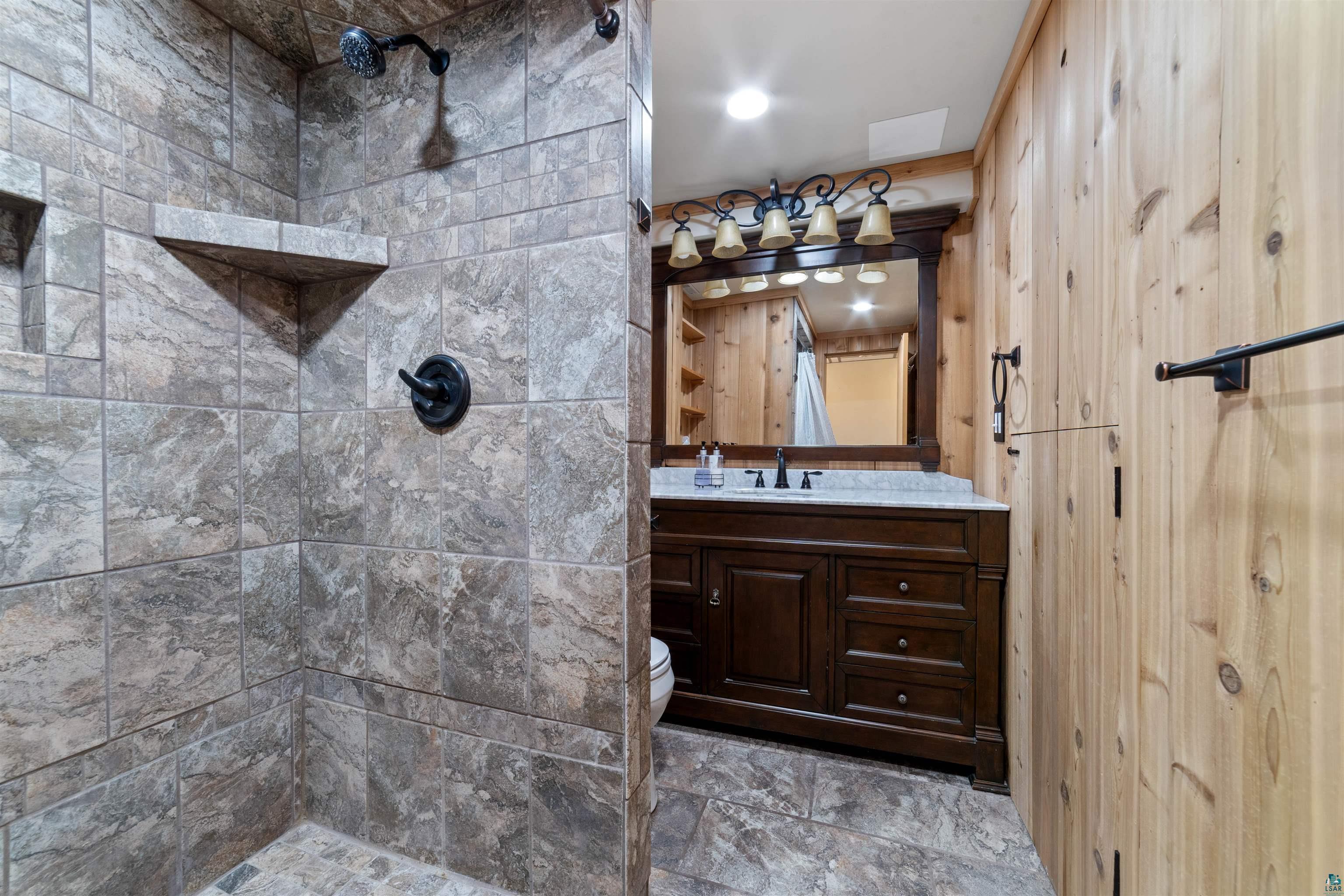 5235 Lakewood Road Duluth, MN 55804 - Photo 20 of 37 Bathroom with toilet, vanity, and a tile shower