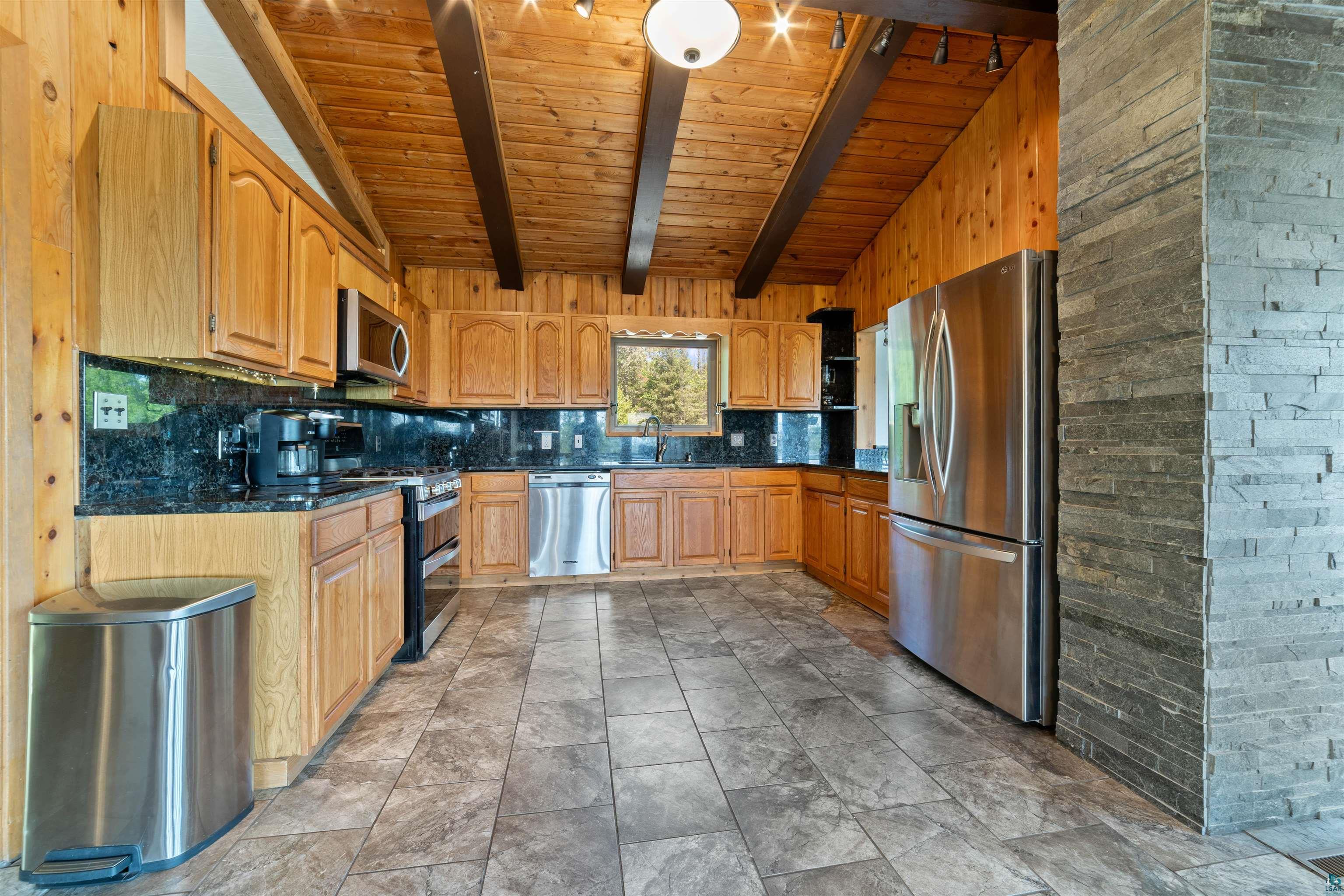 5235 Lakewood Road Duluth, MN 55804 - Photo 5 of 37 Kitchen with vaulted ceiling with beams, tasteful backsplash, stainless steel appliances, sink, and light tile patterned floors