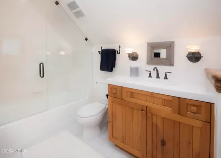 a bathroom with a granite countertop sink a toilet and mirror