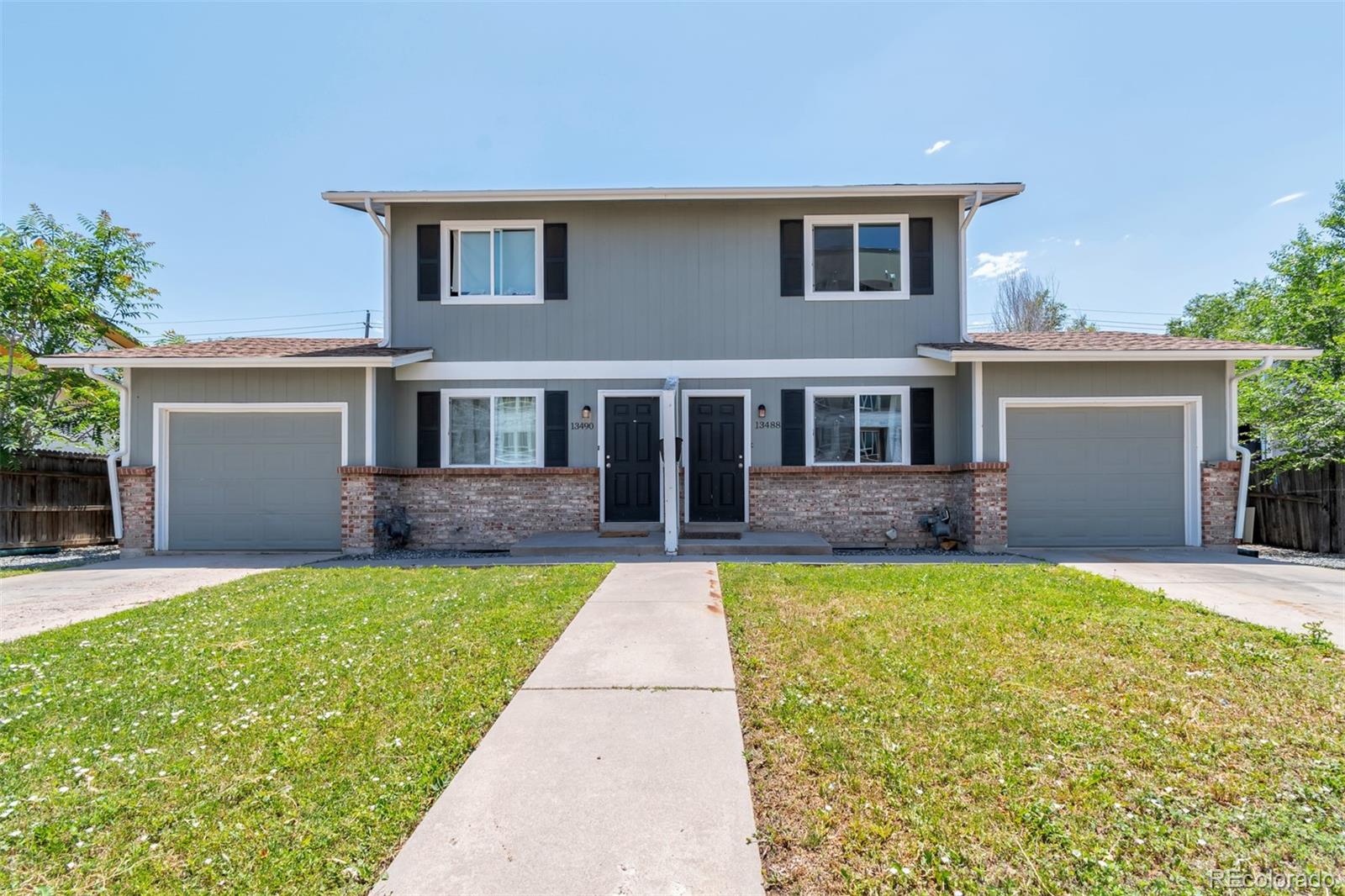 13488 East 13th Place Aurora, CO 80011 - Photo 1 of 15 a front view of a house with a yard and garage