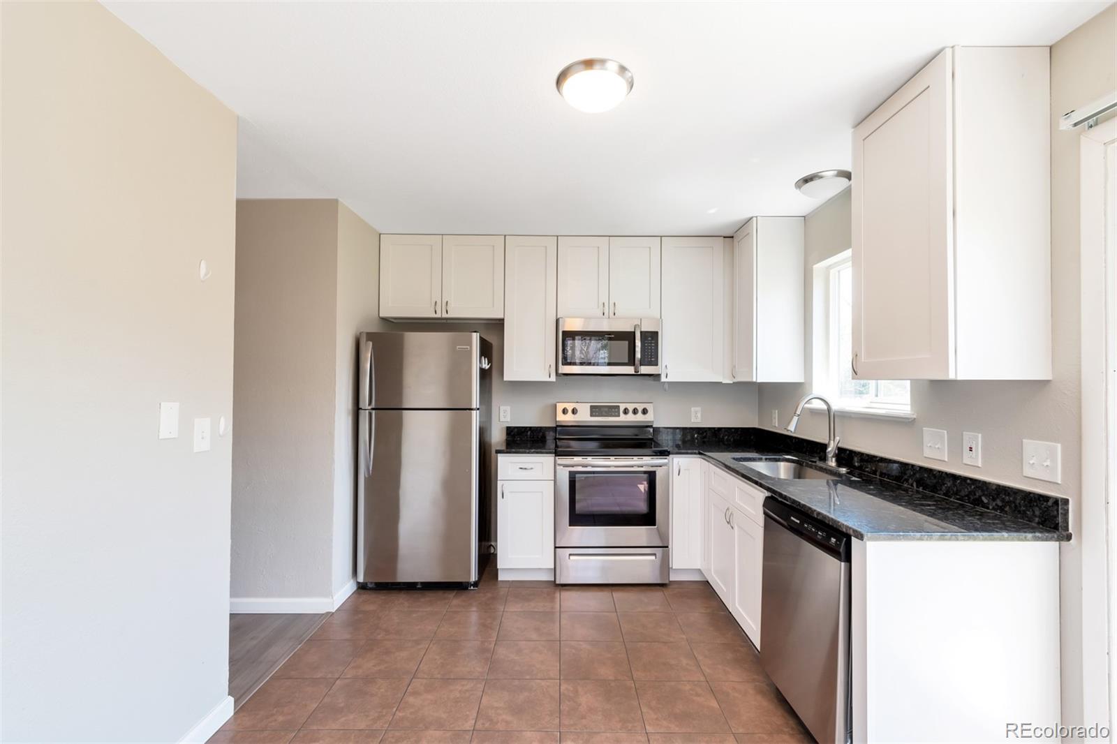13488 East 13th Place Aurora, CO 80011 - Photo 6 of 15 a kitchen with stainless steel appliances granite countertop a stove a refrigerator and a sink