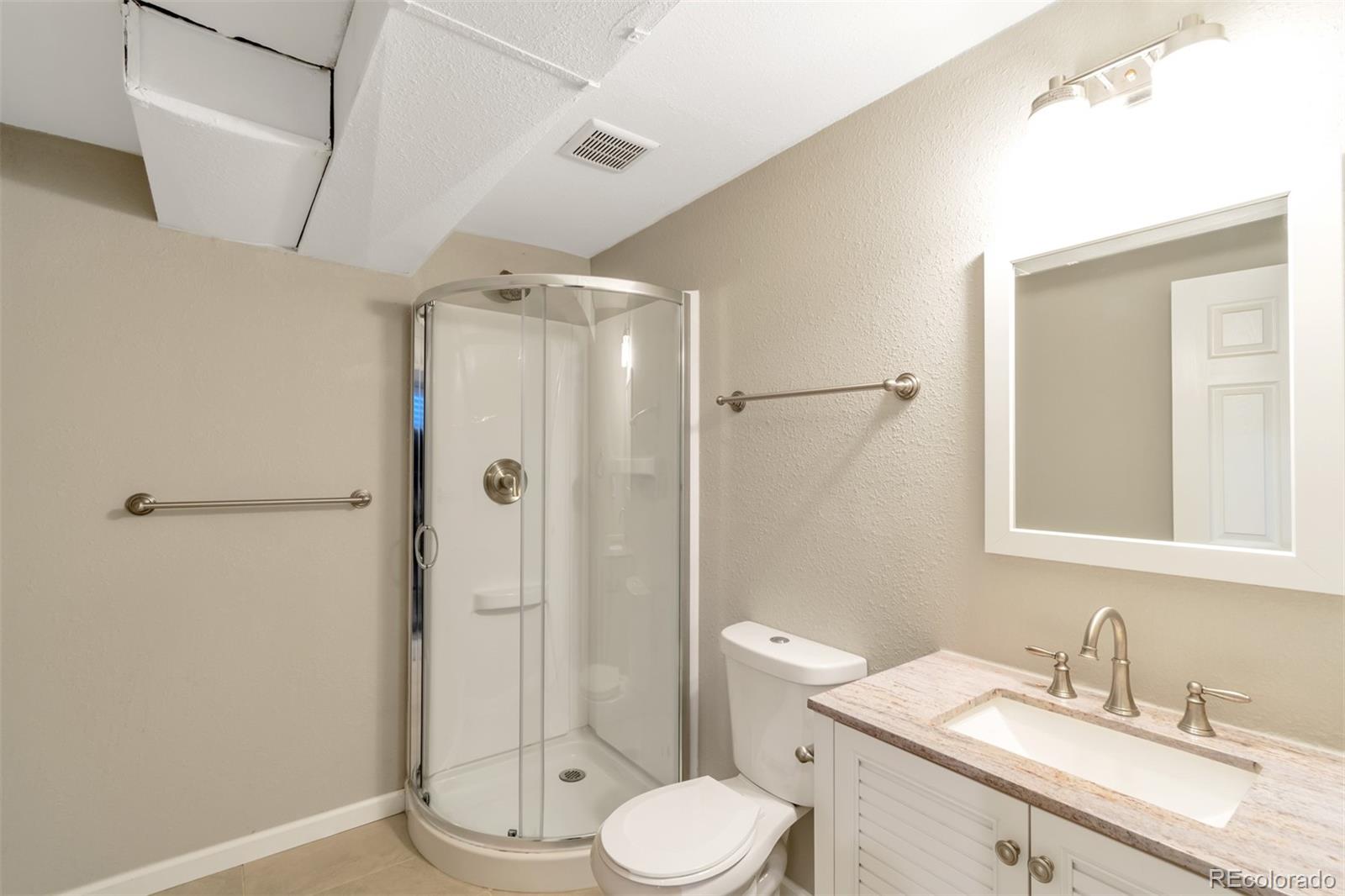 13488 East 13th Place Aurora, CO 80011 - Photo 7 of 15 a bathroom with a granite countertop sink toilet and shower