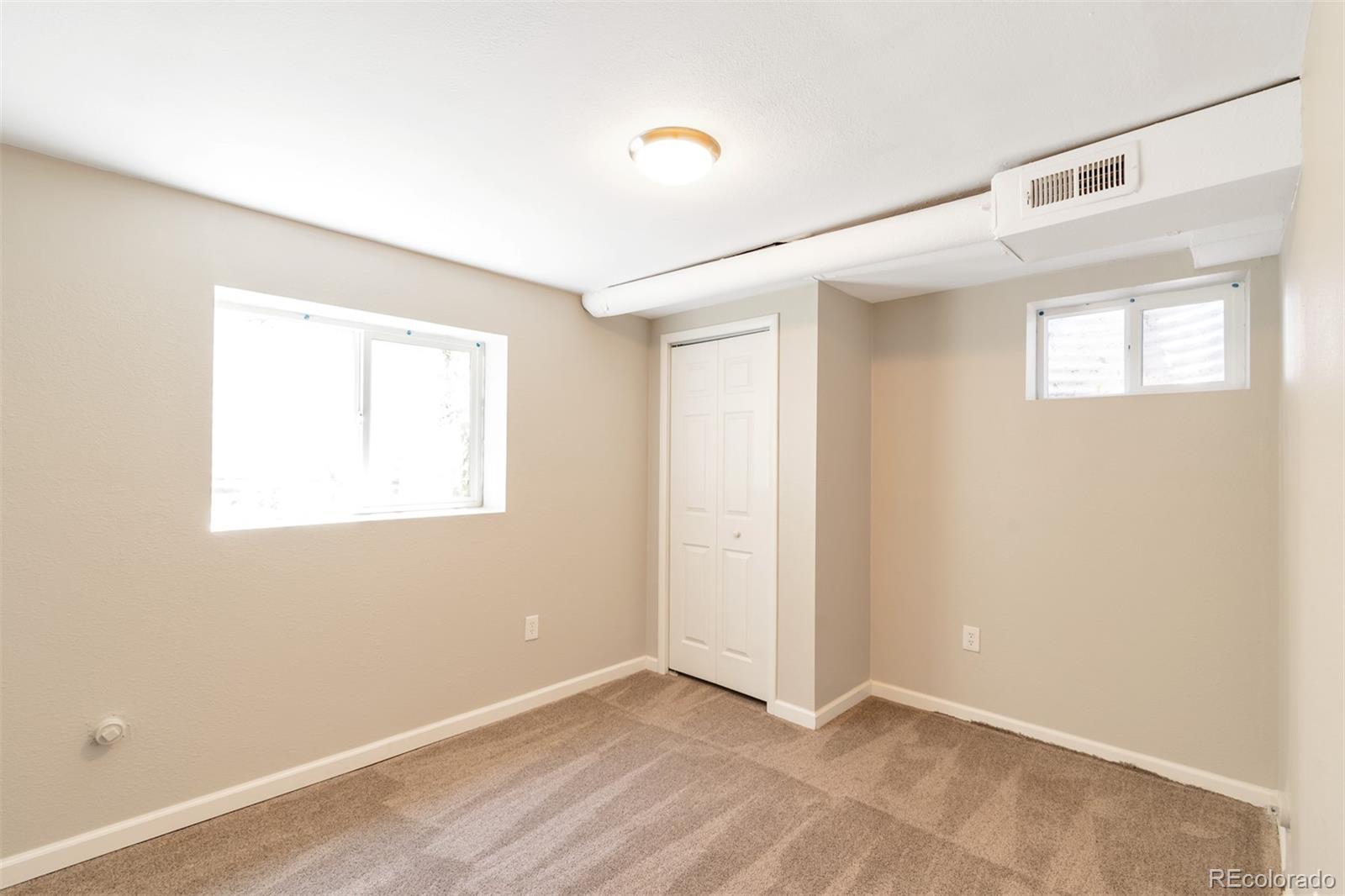 13488 East 13th Place Aurora, CO 80011 - Photo 9 of 15 a view of an empty room with wooden floor and a window