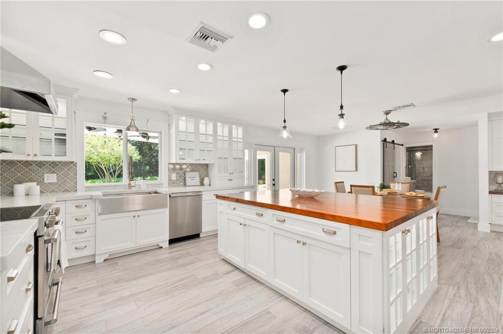 3 Mandalay Road Stuart, FL 34996 - Photo 11 of 65 a large white kitchen with a stove a sink dishwasher and a refrigerator with wooden floor