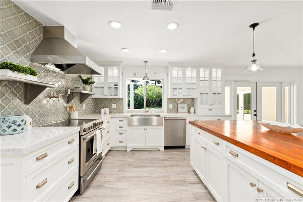 3 Mandalay Road Stuart, FL 34996 - Photo 12 of 65 a large white kitchen with stainless steel appliances granite countertop a lot of counter space and wooden floors