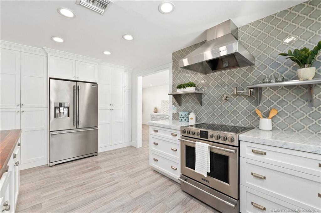 3 Mandalay Road Stuart, FL 34996 - Photo 14 of 65 a kitchen with stainless steel appliances granite countertop a refrigerator and a stove