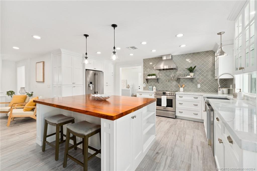 3 Mandalay Road Stuart, FL 34996 - Photo 15 of 65 a large kitchen with stainless steel appliances kitchen island a large island in the center