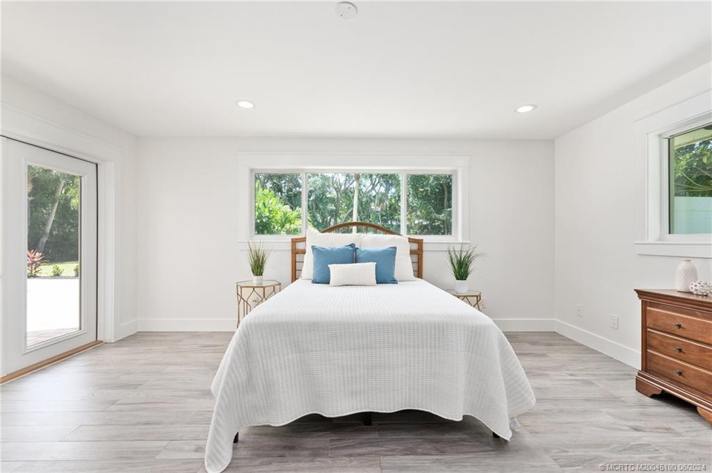 3 Mandalay Road Stuart, FL 34996 - Photo 27 of 65 a large bedroom with a bed and wooden floor