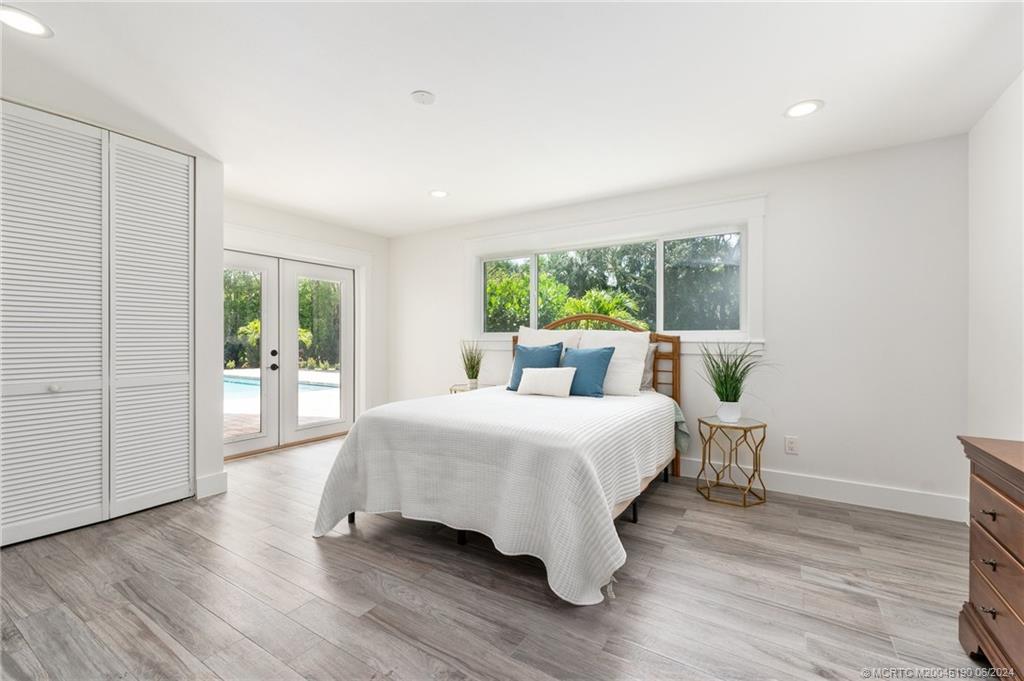3 Mandalay Road Stuart, FL 34996 - Photo 29 of 65 a bedroom with a large bed and a large window