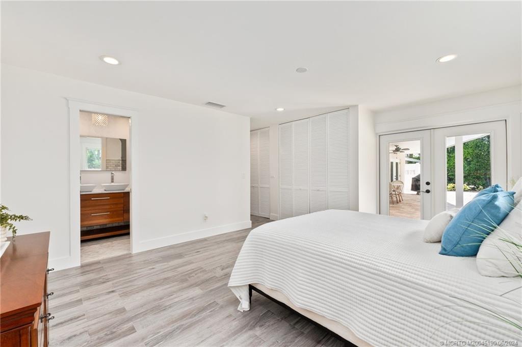 3 Mandalay Road Stuart, FL 34996 - Photo 30 of 65 a spacious bedroom with a bed and a view of kitchen