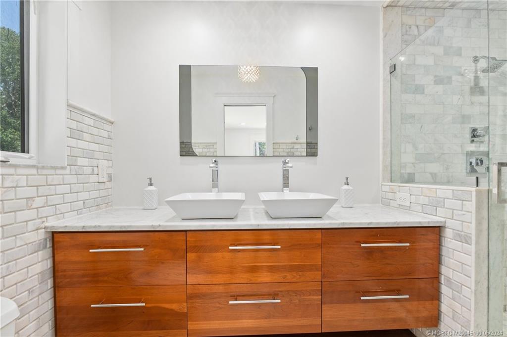 3 Mandalay Road Stuart, FL 34996 - Photo 31 of 65 a bathroom with a granite countertop sink and a mirror