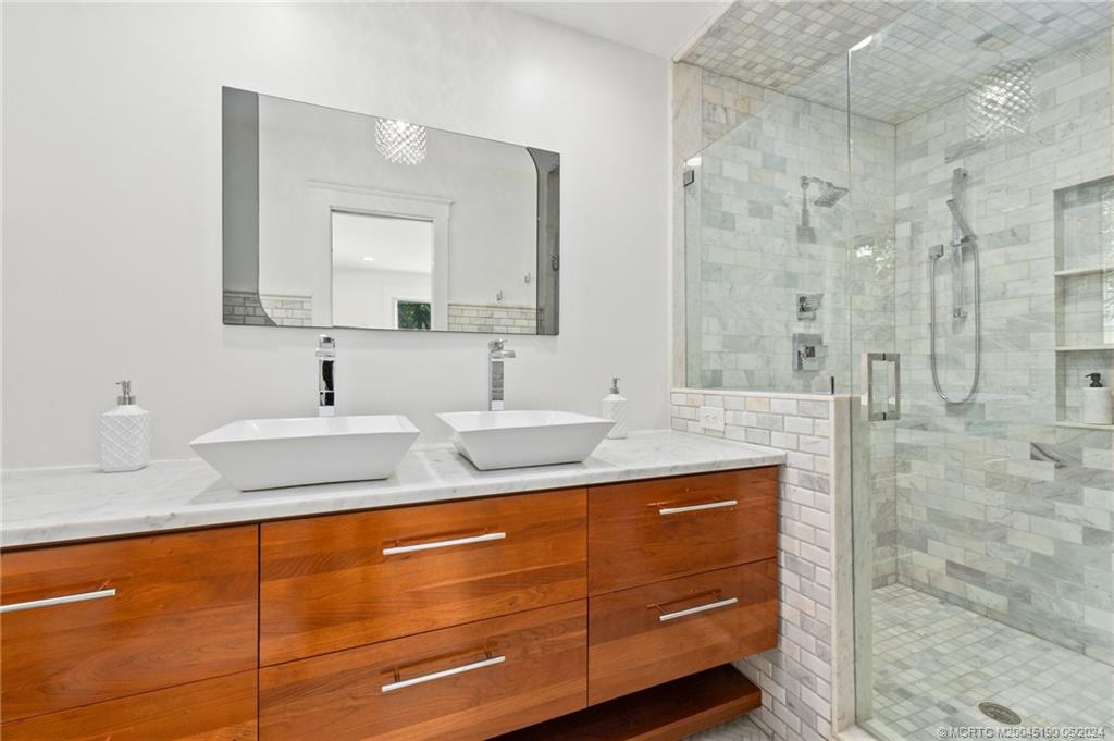 3 Mandalay Road Stuart, FL 34996 - Photo 32 of 65 a bathroom with a granite countertop sink and a mirror