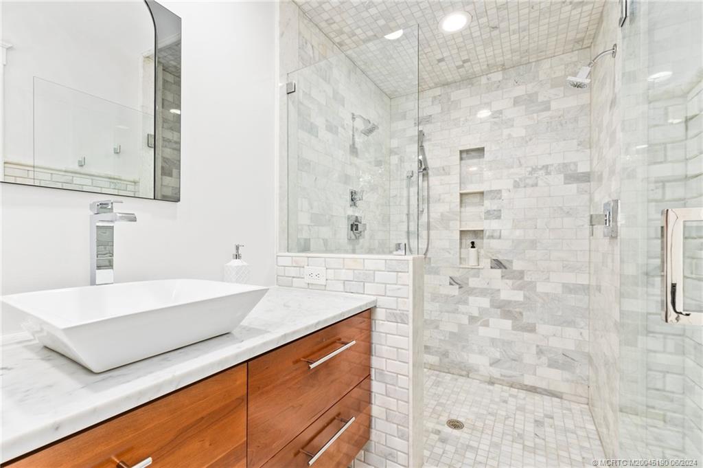3 Mandalay Road Stuart, FL 34996 - Photo 33 of 65 a bathroom with a granite countertop sink a mirror and shower