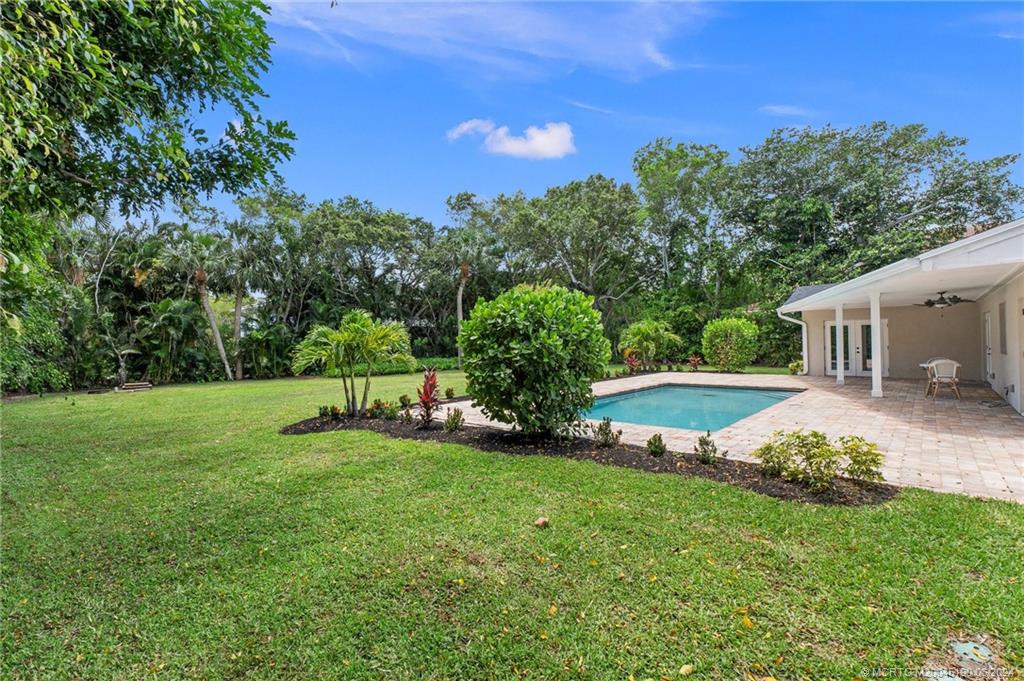 3 Mandalay Road Stuart, FL 34996 - Photo 52 of 65 a view of a house with a swimming pool and a yard