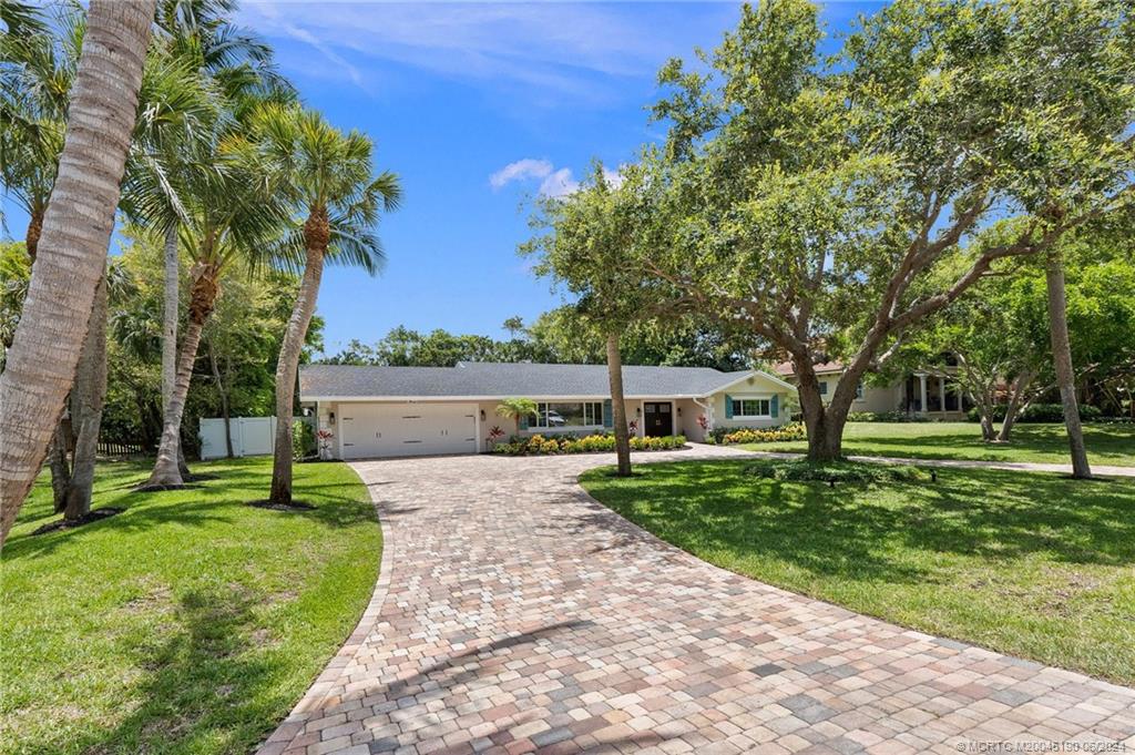 3 Mandalay Road Stuart, FL 34996 - Photo 65 of 65 a front view of a house with a yard and trees