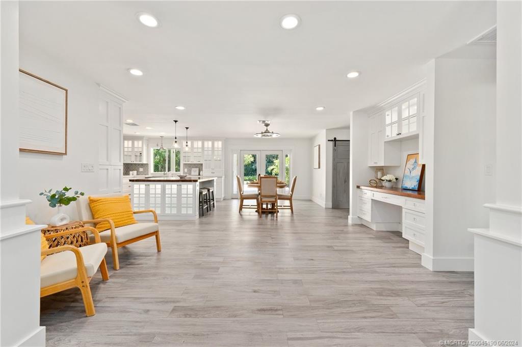 3 Mandalay Road Stuart, FL 34996 - Photo 9 of 65 a living room with furniture and kitchen view with wooden floor
