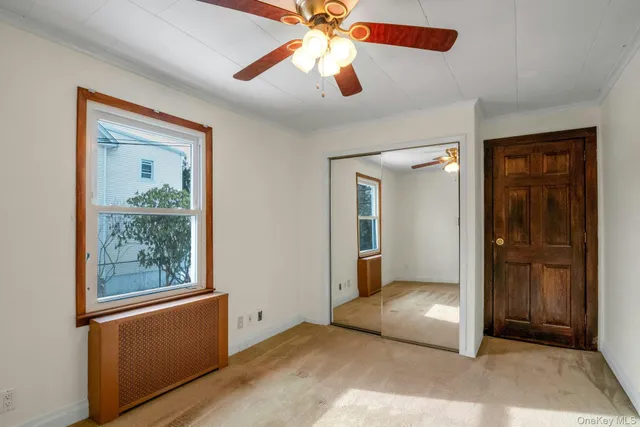 an empty room with fan and windows