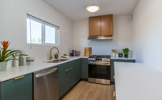 a kitchen with stainless steel appliances granite countertop a sink a stove and cabinets