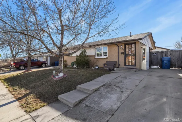 a front view of a house with yard and trees
