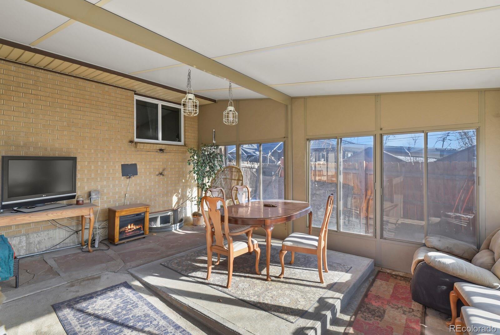 3400 West Mountain Road Englewood, CO 80110 - Photo 18 of 22 a dining room with furniture a flat screen tv and a floor to ceiling window