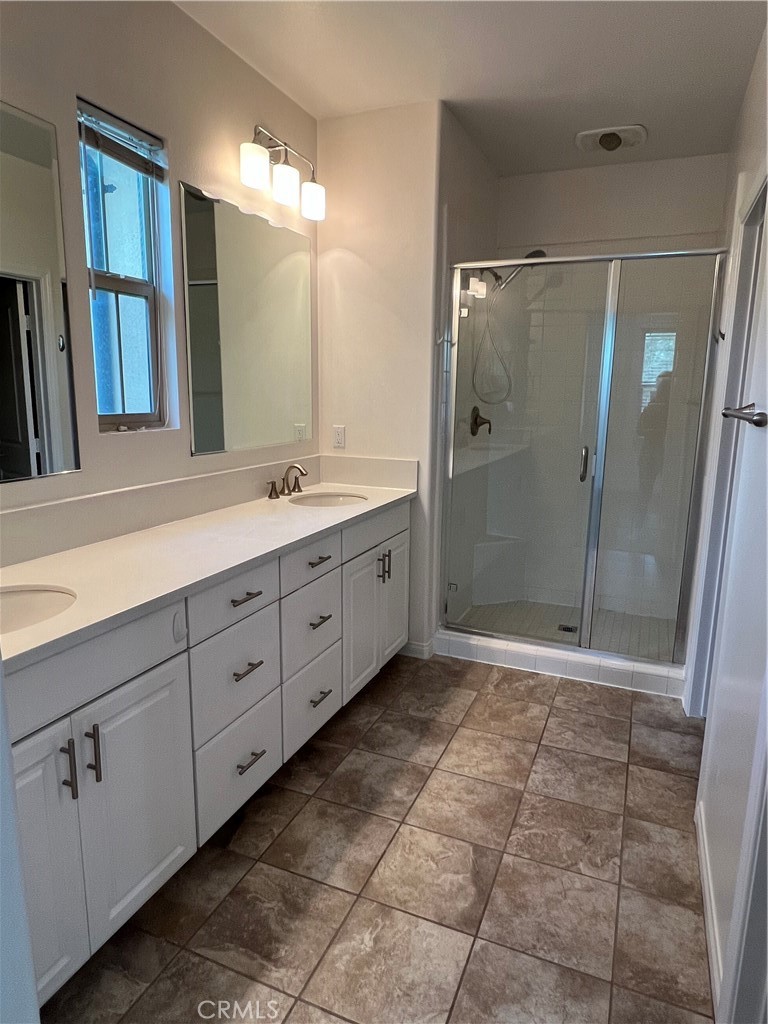 104 Rose Arch Irvine, CA 92620 - Photo 7 of 12 a bathroom with a granite countertop sink a mirror and a shower