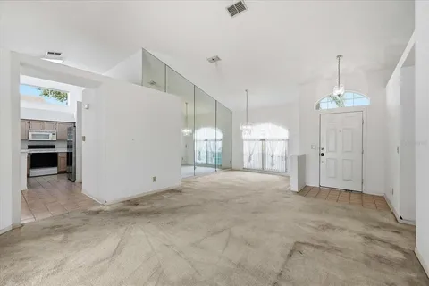 a kitchen with stainless steel appliances granite countertop a sink a stove a refrigerator a washer and dryer next to a window