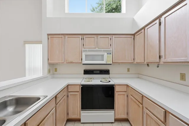 a kitchen with cabinets appliances a sink and a counter top