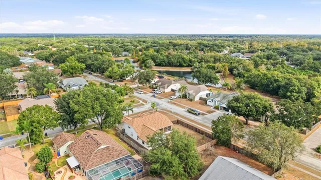 an aerial view of residential houses with outdoor space and trees