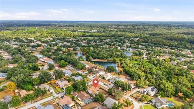 an aerial view of residential houses with outdoor space and trees