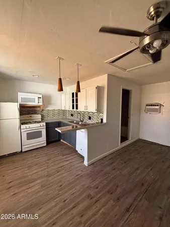 a large kitchen with cabinets wooden floor and stainless steel appliances