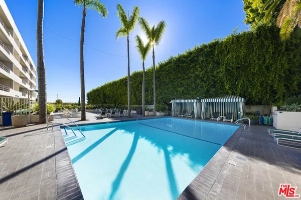 a view of a backyard with swimming pool and furniture