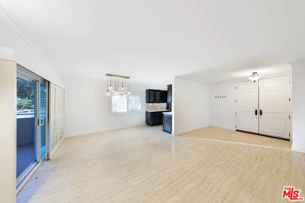 a view of a big room with windows and chandelier fan