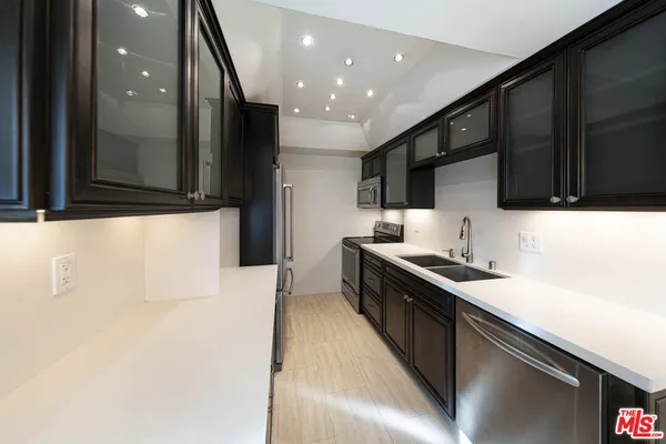 a kitchen with stainless steel appliances a sink stove and cabinets