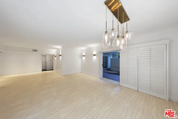 wooden floor in an empty room with a chandelier