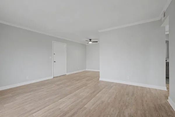 a view of an empty room with wooden floor