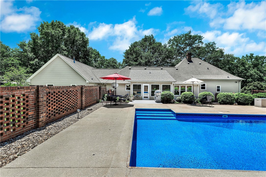 910 Chantilly Lane Anderson, SC 29625 - Photo 30 of 38 An inviting backyard oasis features a glistening pool and a spacious patio area.