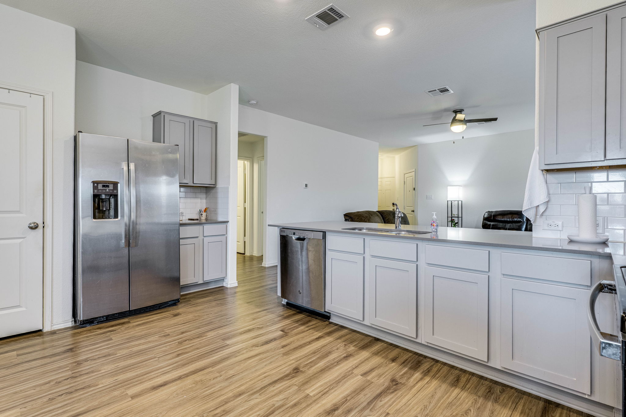 557 Greatest Gift Way Jarrell, TX 76537 - Photo 39 of 39 Kitchen featuring stainless steel appliances, backsplash, a peninsula, light wood finished floors, and open floor plan