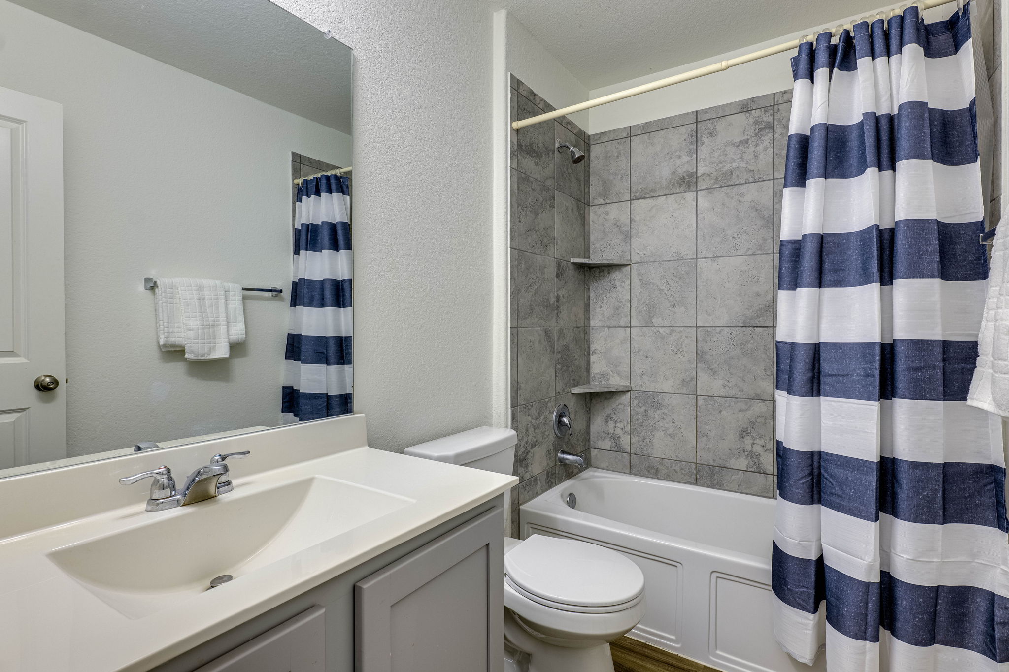 557 Greatest Gift Way Jarrell, TX 76537 - Photo 18 of 39 Full bathroom with a textured wall, shower / tub combo with curtain, and vanity