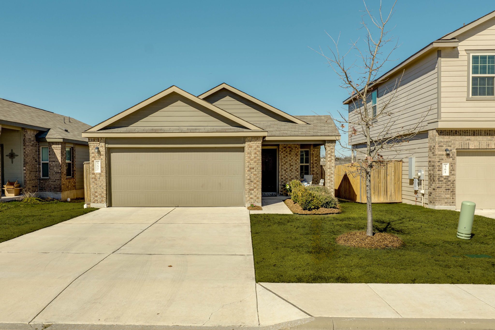 557 Greatest Gift Way Jarrell, TX 76537 - Photo 2 of 39 View of front of property featuring concrete driveway, a garage, and brick siding